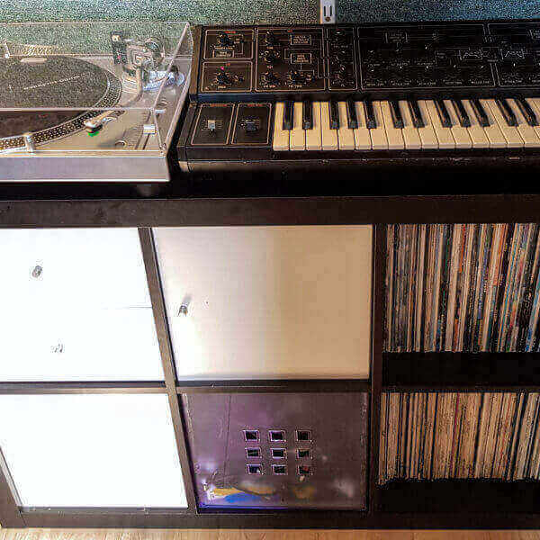 turntable, keyboard and shelves of vinyl
