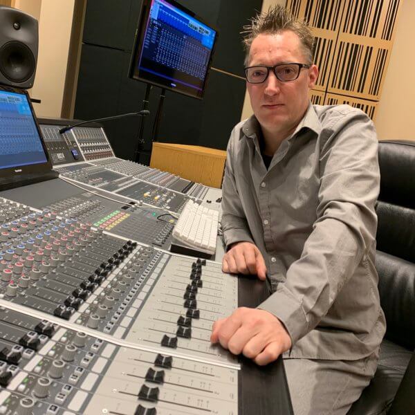 KCKCC Professor sitting at Audient mixing console