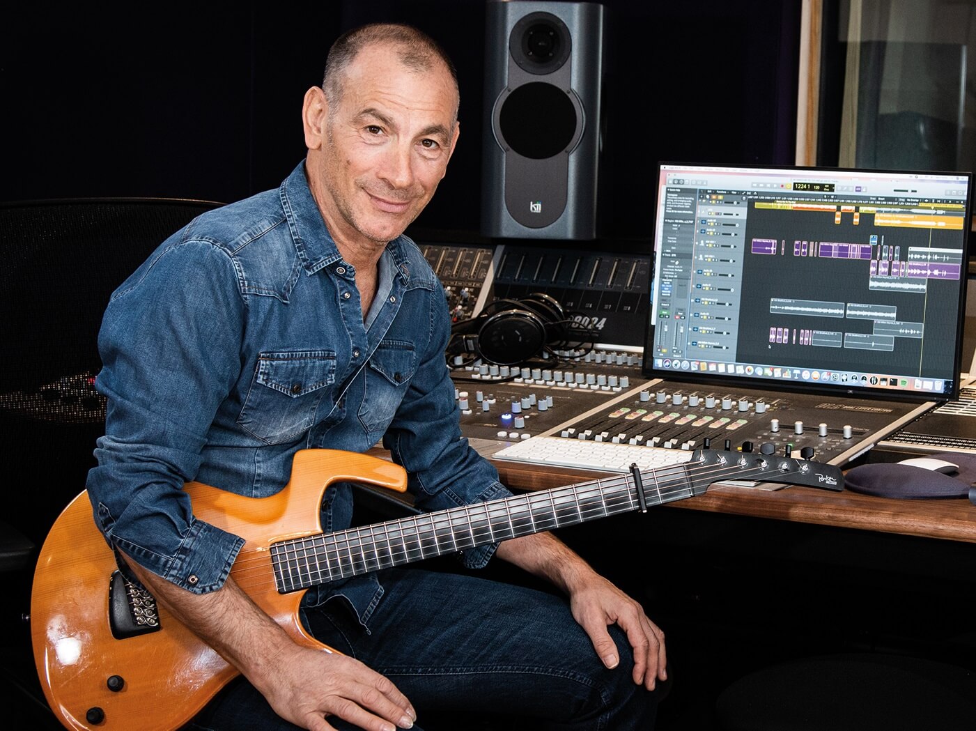 Carmelo Luggeri sitting at his Audient ASP8024-HE Mixing console