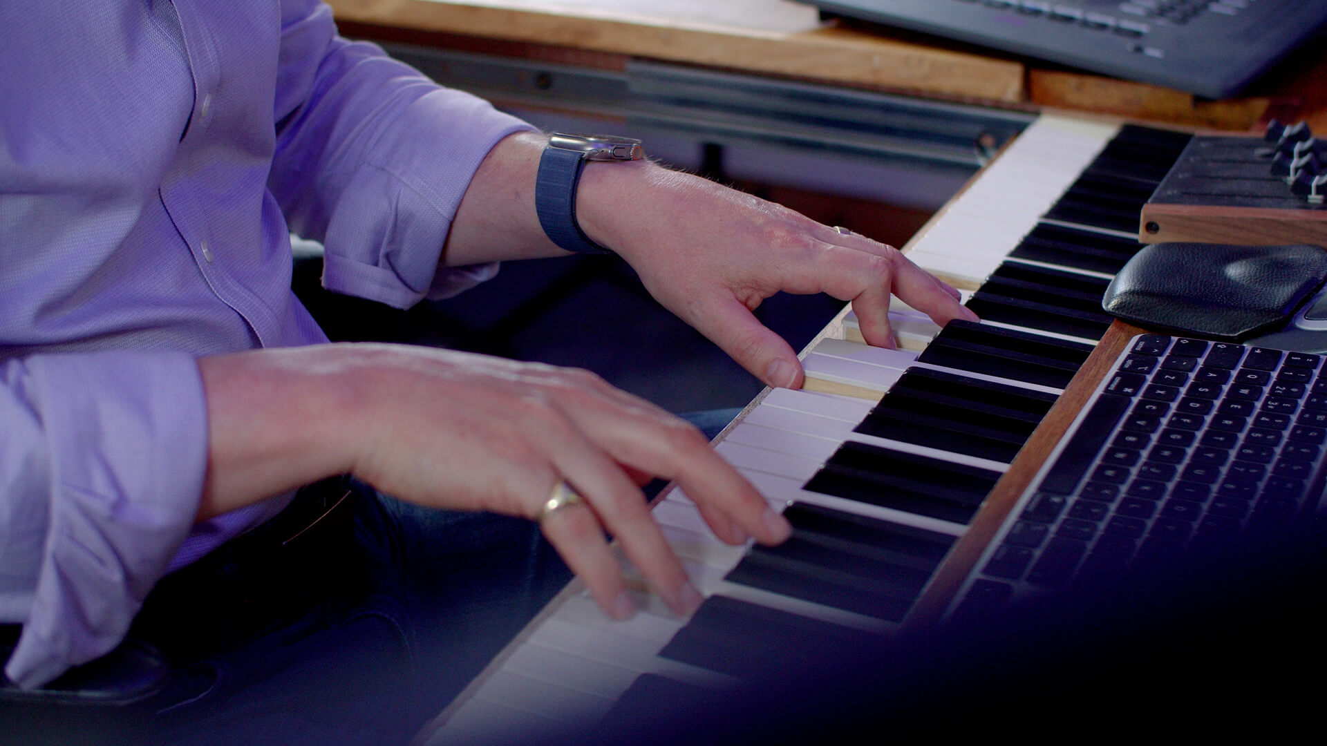 Hilgrove Kenrick playing the keyboard in his writing room