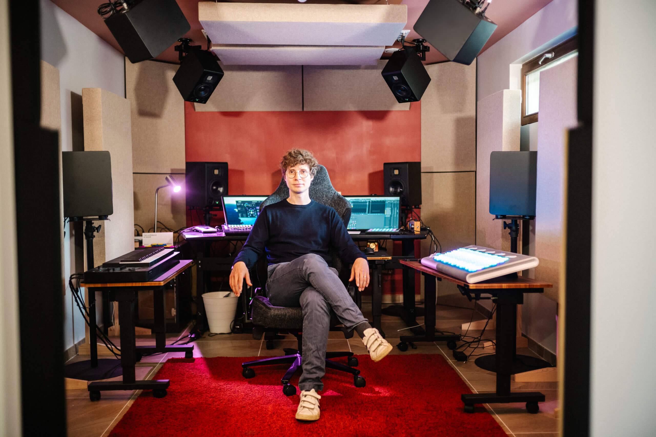 writer Grégory Betton sitting in front of his workstation surrounded by studio attributes 